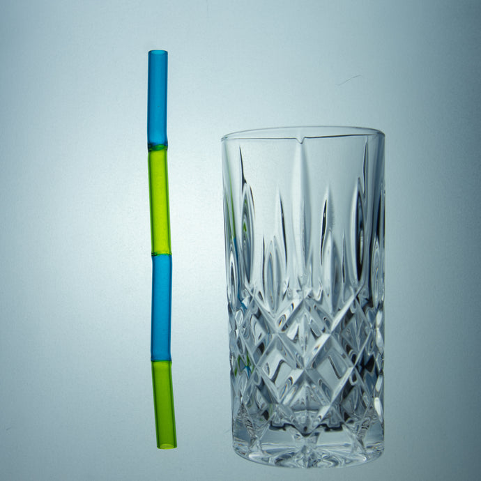 Blau-Grüner Glastrinkhalm neben Longdrinkglas